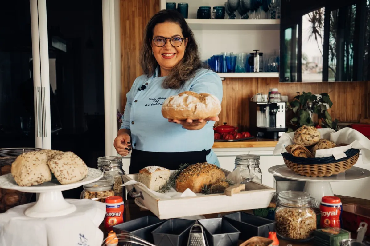 Chef Vanda Hering segurando um pão low carb na cozinha