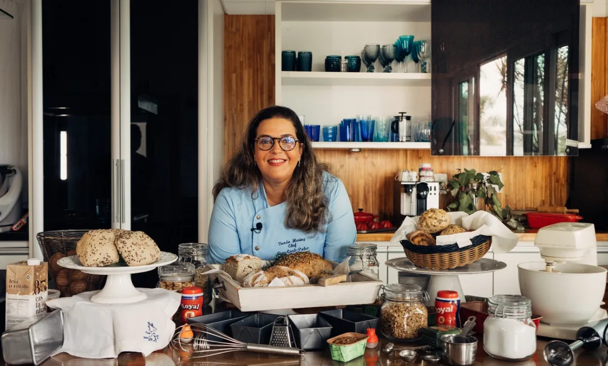 Chef Vanda Hering na cozinha cercada de pães low carb e ingredientes